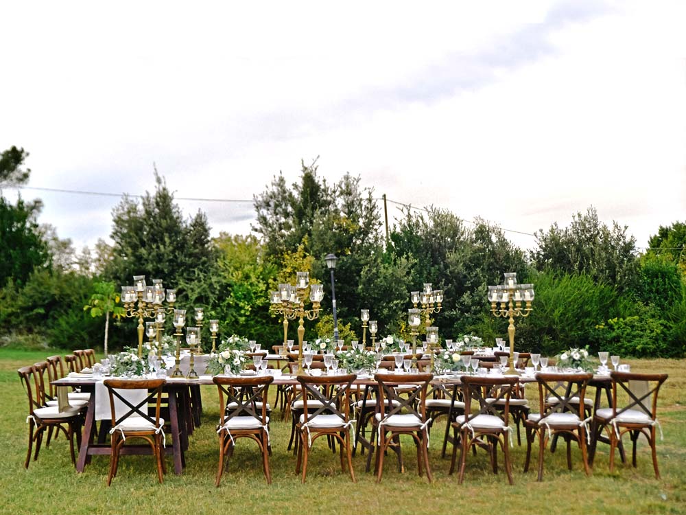 Table de banquet avec candélabres dressée au milieu d'un champ