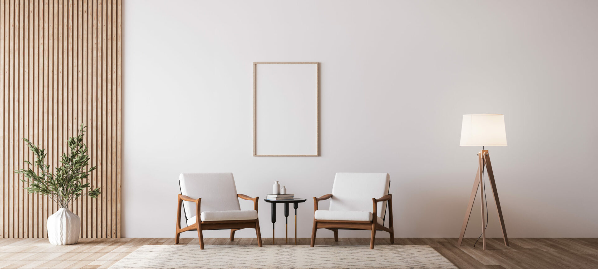 Deux fauteuils design en bois et tissu blanc encadrent une toute petite table. Au milieu sur le mur, un  cadre en bois vide. À droite, un lampadaire en bois et abat-jour blanc, à gauche un vase blanc et branchages verts.